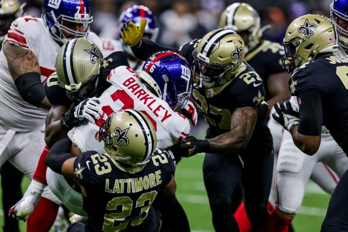 Giants running back Saquon Barkley (26) is tackled by New Orleans Saints cornerback Marshon Lattimore (23) and safety Malcolm Jenkins (27). Mandatory Credit: Stephen Lew-USA TODAY